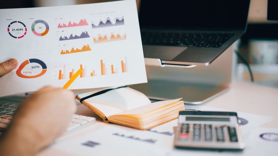 Charts and a calculator on a desk during a funding review